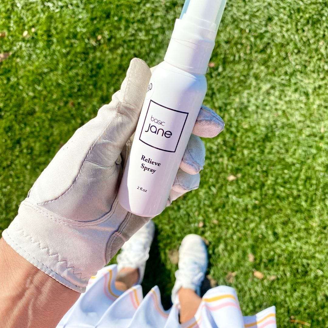 Relieve Pain CBD Spray in golfers hand. Point and spray pain sprays for relief.  CBD products commonly used by seniors and athletes